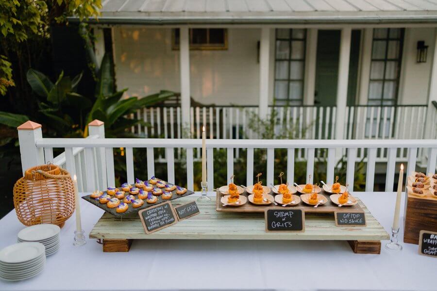 food spread of appetizers on a white tablecloth outside on porch