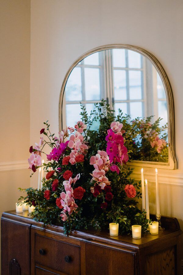 Stunning bouquet of flowers on a side table under a mirror