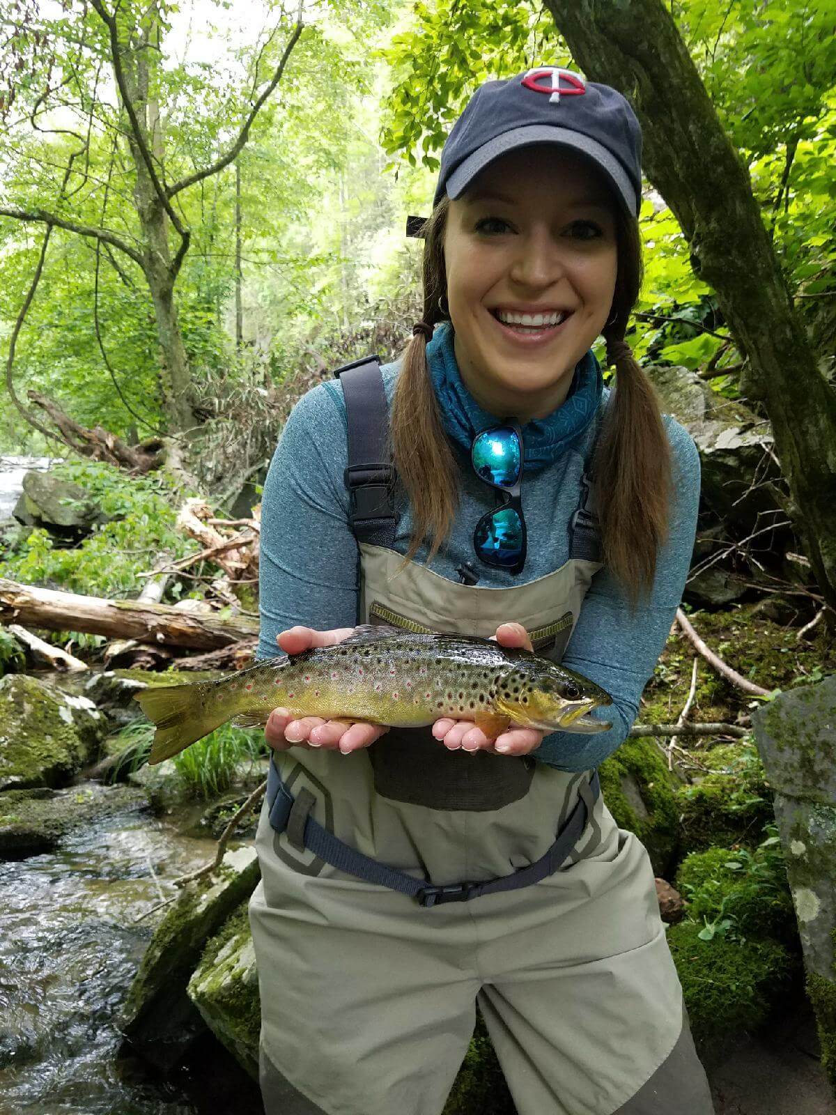 Young woman hold trout she caught fly fishing in Gatlinburg, TN