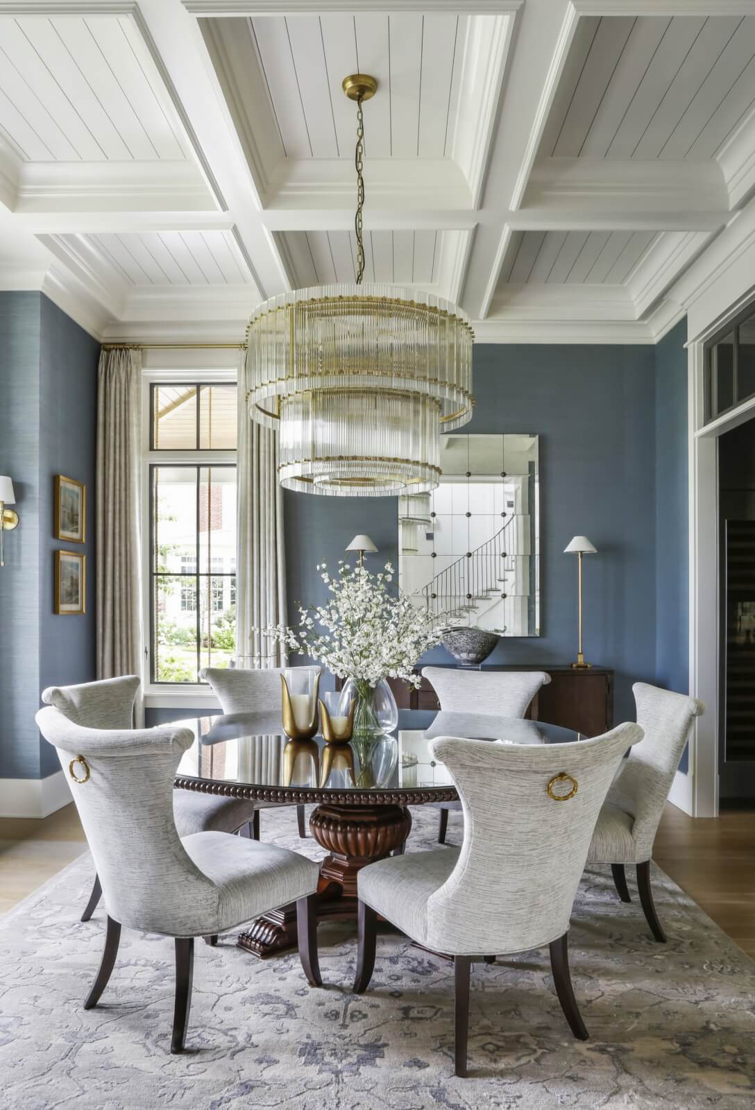 Dining room with blue walls and an elegant chandelier.