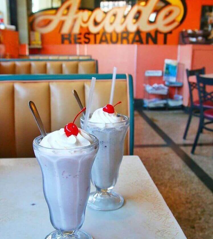 Two boozy shakes topped with whipped cream and a cherry