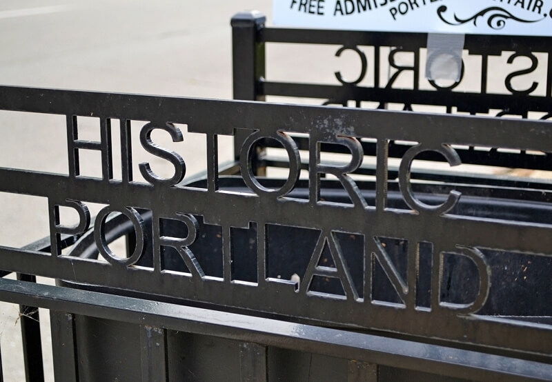 Wrought iron Historic Portland signage on a garbage can.