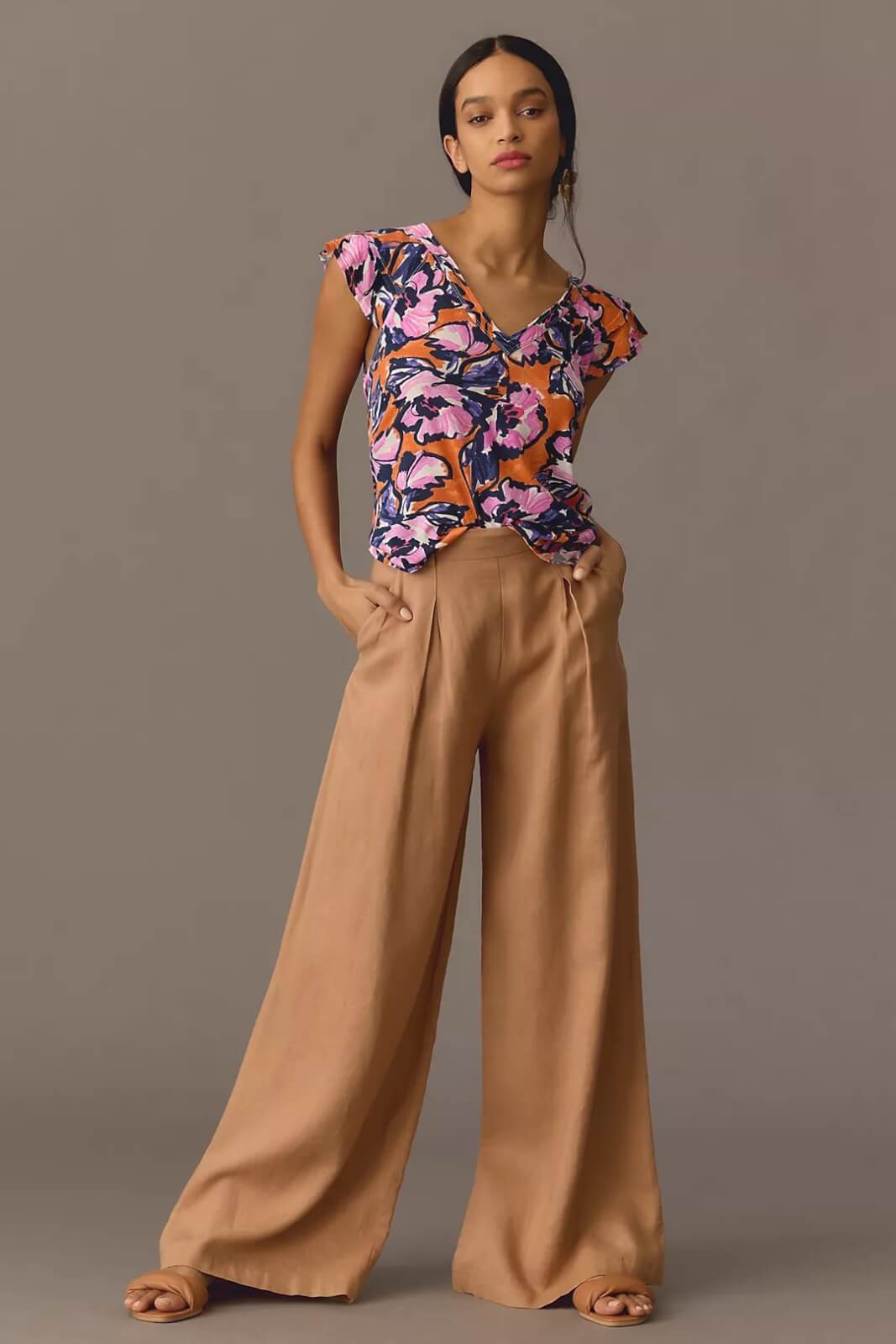 Model in orange floral blouse and wide-leg pants