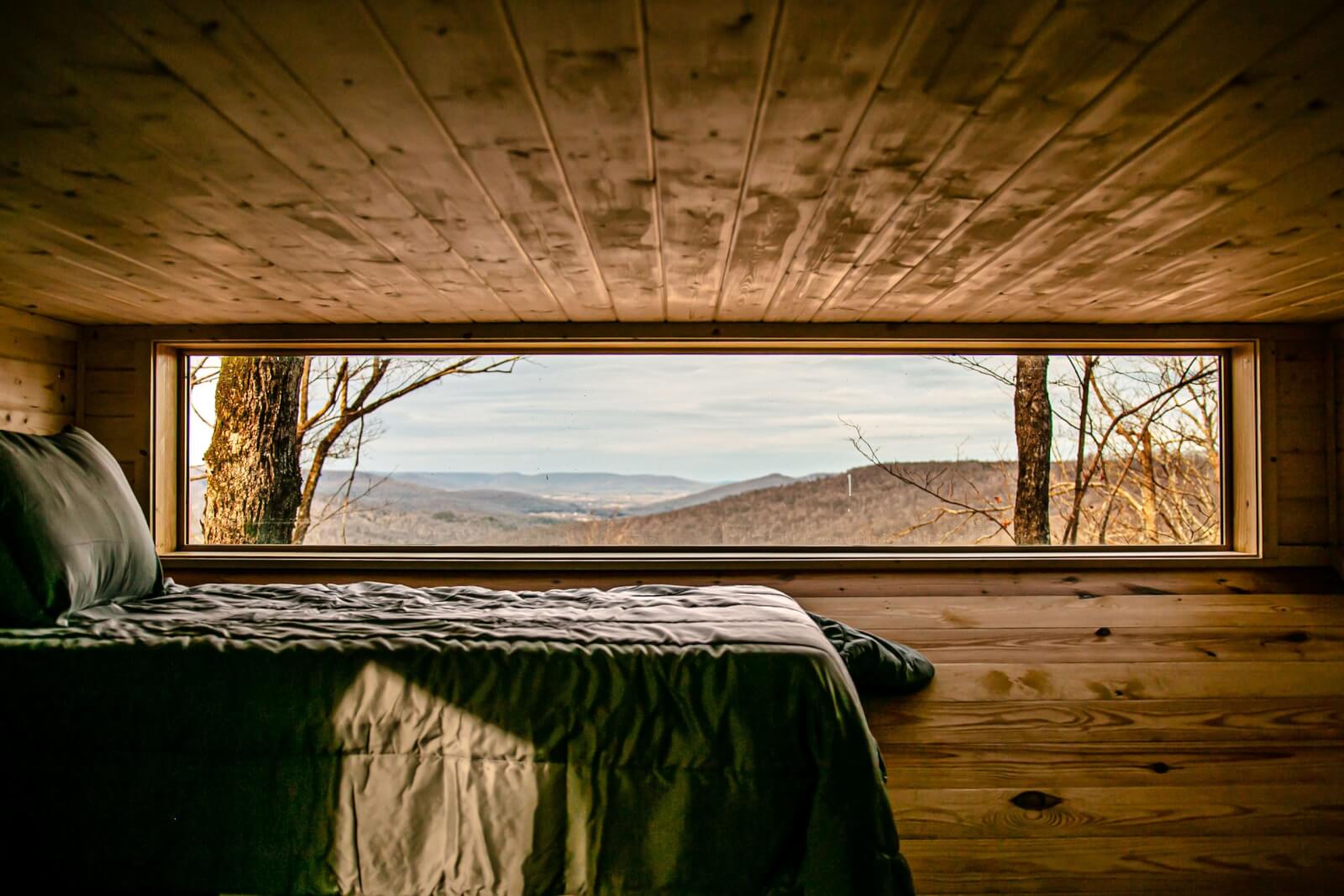Bed in dark room with a window that overlooks the Cumberland Plateau.