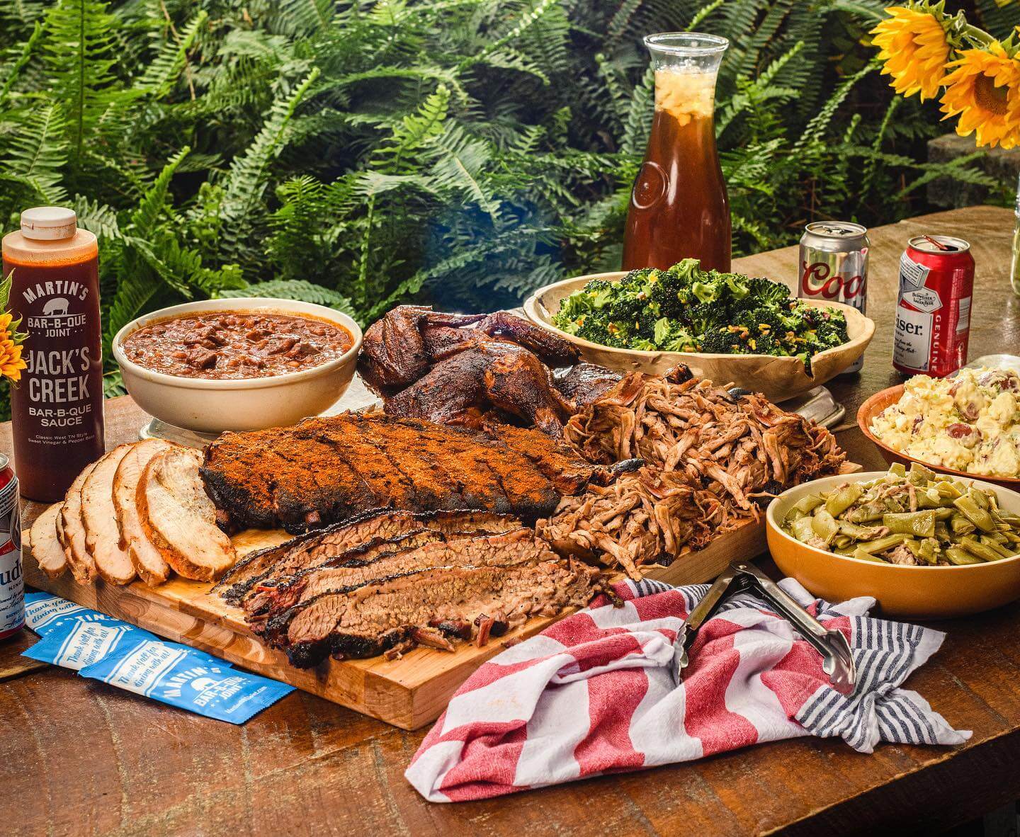 Wooden board filled with barbecue and sides